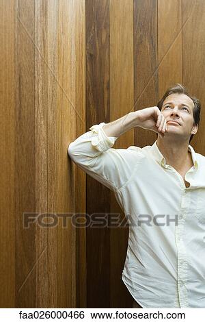 Man leaning elbow against wall, holding chin, looking up View Large Photo Image Stock Photograph - Man leaning elbow against wall, holding chin, looking up. Fotosearch
