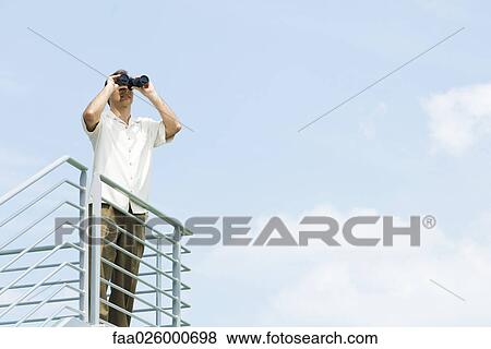 Man looking through binoculars View Large Photo Image Stock Photo - Man looking through binoculars. Fotosearch