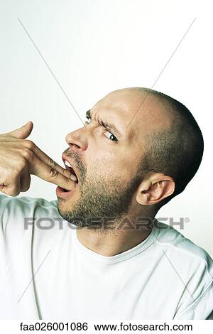 Man making gun gesture, holding fingers in mouth, looking at camera, side view View Large Photo Image Stock Photograph - Man making gun gesture, holding fingers in mouth, looking at camera, side view. Fotosearch
