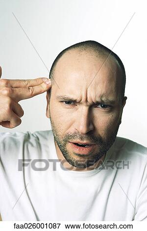 Man making gun gesture, pointing at temple, looking at camera View Large Photo Image Stock Photo - Man making gun gesture, pointing at temple, looking at camera. Fotosearch