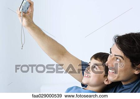Man photographing self with young son, both smiling View Large Photo Image Stock Photo - Man photographing self with young son, both smiling. Fotosearch
