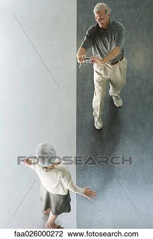 Man photographing wife with digital camera, viewed from directly above View Large Photo Image Stock Image - Man photographing wife with digital camera, viewed from directly above. Fotosearch