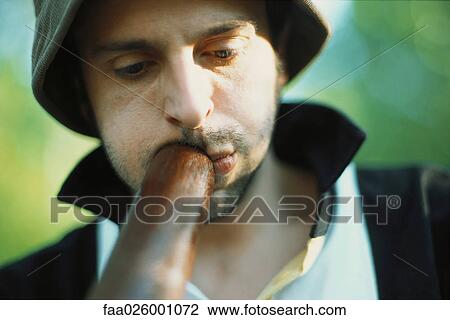 Stock Image - Man playing didgeridoo, looking down, close-up. Fotosearch