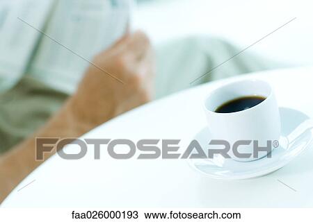 Man reading newspaper, focus on coffee cup in foreground View Large Photo Image Stock Image - Man reading newspaper, focus on coffee cup in foreground. Fotosearch