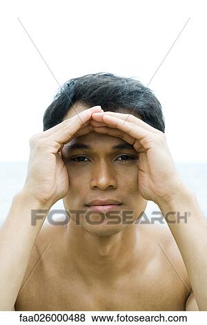 Man shading eyes, looking at camera, portrait View Large Photo Image Stock Photo - Man shading eyes, looking at camera, portrait. Fotosearch