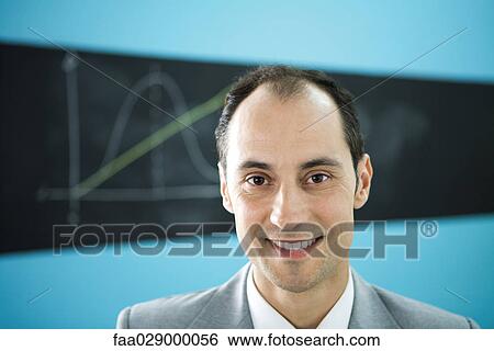 Man smiling at camera, diagram drawn on blackboard in the background View Large Photo Image Stock Photograph - Man smiling at camera, diagram drawn on blackboard in the background. Fotosearch