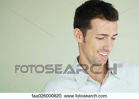 Man smiling, looking down, head and shoulders, portrait View Large Photo Image Stock Image - Man smiling, looking down, head and shoulders, portrait. Fotosearch
