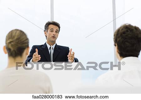 Man speaking at lectern, audience seated in foreground View Large Photo Image Stock Image - Man speaking at lectern, audience seated in foreground. Fotosearch