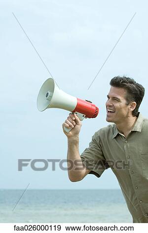 Man standing by the sea, shouting into megaphone, close-up View Large Photo Image Stock Photo - Man standing by the sea, shouting into megaphone, close-up. Fotosearch