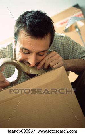 Stock Photo - Man tearing tape with teeth. Fotosearch