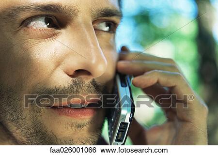 Man using cell phone, looking away, close-up View Large Photo Image Stock Photograph - Man using cell phone, looking away, close-up. Fotosearch