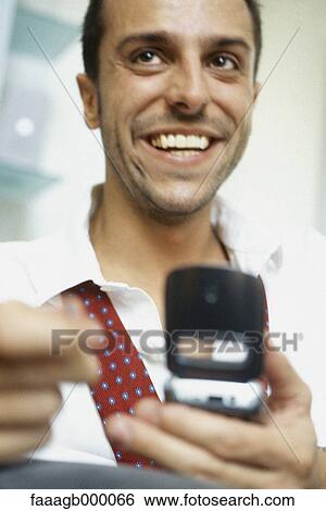 Man using cell phone, smiling View Large Photo Image Stock Photograph - Man using cell phone, smiling. Fotosearch