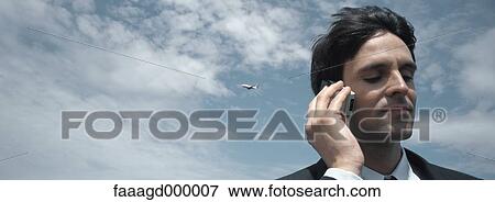 Man using telephone, airplane in sky View Large Photo Image Stock Photo - Man using telephone, airplane in sky. Fotosearch