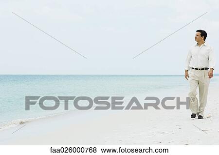 Man walking across beach, looking at distance, full length, front view View Large Photo Image Stock Photo - Man walking across beach, looking at distance, full length, front view. Fotosearch