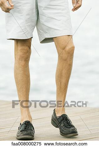 Stock Photography - Man walking on dock, waist down. Fotosearch