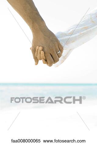 Married couple holding hands on beach, close-up of hands View Large Photo Image Stock Photography - Married couple holding hands on beach, close-up of hands. Fotosearch