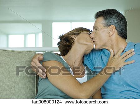 Mature couple kissing on sofa View Large Photo Image Picture - Mature couple kissing on sofa. Fotosearch