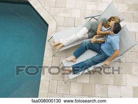 Mature couple lying by edge of pool, kissing View Large Photo Image Stock Image - Mature couple lying by edge of pool, kissing. Fotosearch