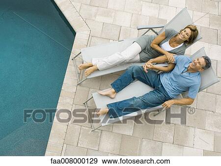 Mature couple lying by edge of pool View Large Photo Image Stock Photo - Mature couple lying by edge of pool. Fotosearch