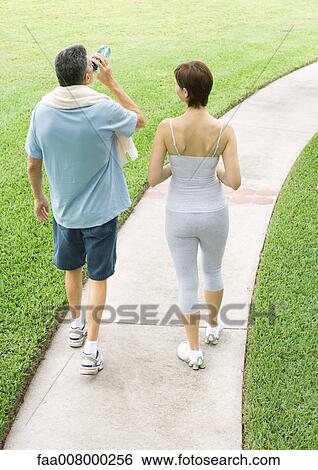 Mature couple walking on path after workout View Large Photo Image Stock Photograph - Mature couple walking on path after workout. Fotosearch