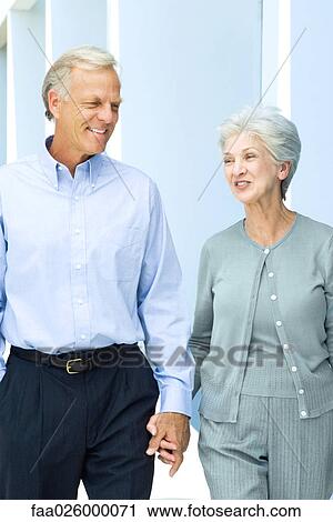 Mature couple walking together, holding hands, close-up View Large Photo Image Stock Image - Mature couple walking together, holding hands, close-up. Fotosearch