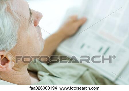 Mature man reading newspaper, high angle view, cropped View Large Photo Image Picture - Mature man reading newspaper, high angle view, cropped. Fotosearch