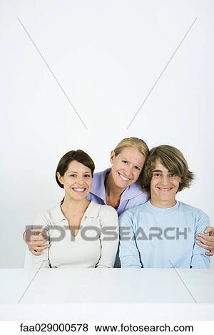 Mature woman embracing younger woman and teen boy, all smiling, portrait View Large Photo Image Stock Photo - Mature woman embracing younger woman and teen boy, all smiling, portrait. Fotosearch