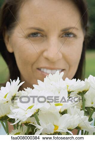 Mature woman's face and bunch of daisies View Large Photo Image Picture - Mature woman's face and bunch of daisies. Fotosearch