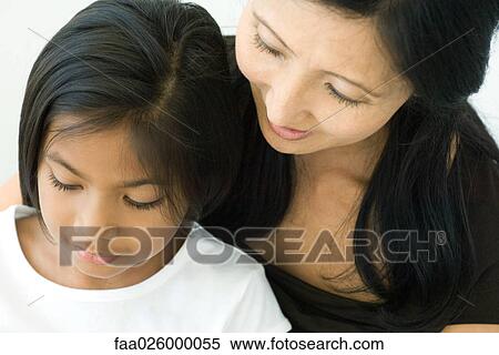 Mother and daughter looking down together, close-up View Large Photo Image Stock Photography - Mother and daughter looking down together, close-up. Fotosearch