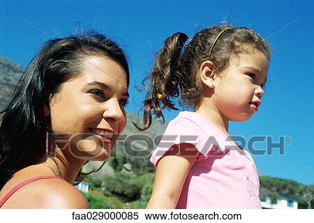 Mother and daughter outdoors, looking away, smiling View Large Photo Image Stock Photography - Mother and daughter outdoors, looking away, smiling. Fotosearch