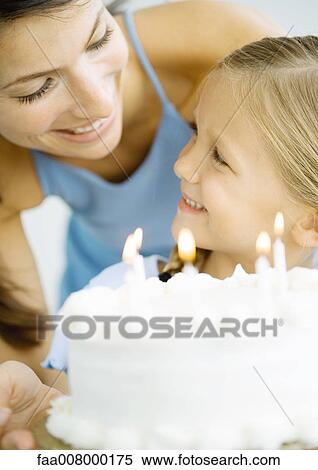Mother and daughter with birthday cake, smiling at each other View Large Photo Image Stock Photography - Mother and daughter with birthday cake, smiling at each other. Fotosearch