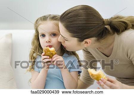 Mother and little girl eating croissants, girl looking at camera View Large Photo Image Stock Photo - Mother and little girl eating croissants, girl looking at camera. Fotosearch
