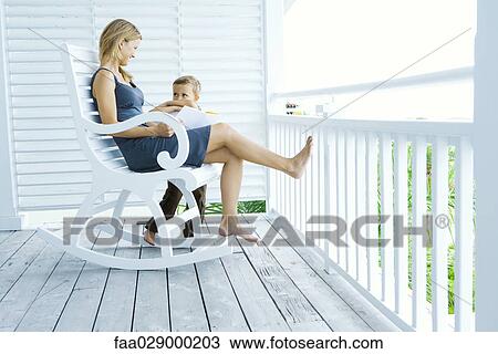 Mother and son on porch, smiling at each other, woman holding book View Large Photo Image Stock Image - Mother and son on porch, smiling at each other, woman holding book. Fotosearch