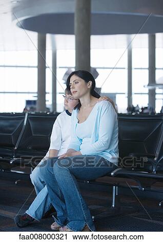 Mother and son sitting in airport lounge View Large Photo Image Stock Image - Mother and son sitting in airport lounge. Fotosearch