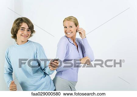 Mother and teen son listening to MP3 player together, dancing, smiling at camera View Large Photo Image Stock Image - Mother and teen son listening to MP3 player together, dancing, smiling at camera. Fotosearch