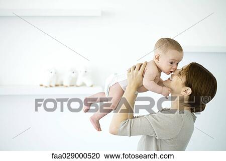 Mother holding baby up to face, smiling, side view View Large Photo Image Stock Image - Mother holding baby up to face, smiling, side view. Fotosearch