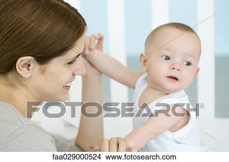 Mother holding baby's hands, close-up View Large Photo Image Picture - Mother holding baby's hands, close-up. Fotosearch