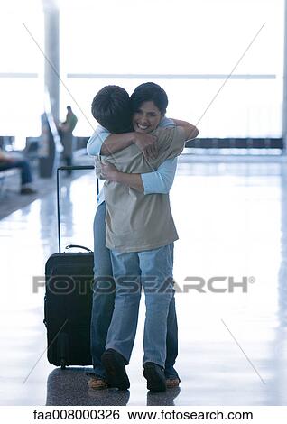 Mother hugging son in airport View Large Photo Image Stock Photograph - Mother hugging son in airport. Fotosearch