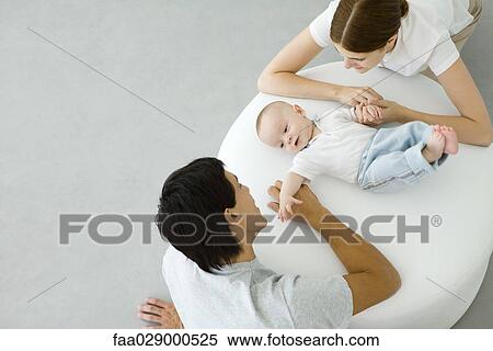New parents with infant, high angle view View Large Photo Image Stock Photography - New parents with infant, high angle view. Fotosearch
