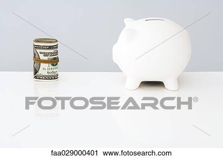 Piggy bank facing roll of twenty dollar bills View Large Photo Image Stock Image - Piggy bank facing roll of twenty dollar bills. Fotosearch