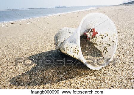 Stock Image - Plastic cup on beach. Fotosearch