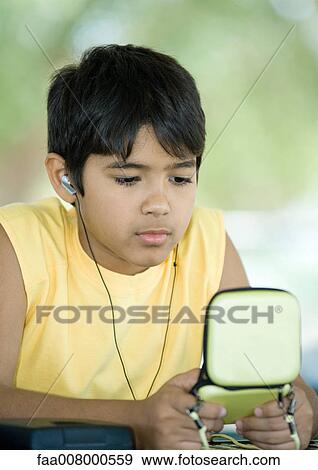 Preteen boy wearing earphones and holding case View Large Photo Image Stock Photo - Preteen boy wearing earphones and holding case. Fotosearch