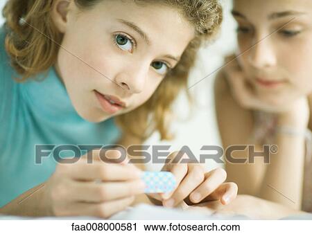 Preteen girl filing nails while friend watches View Large Photo Image Stock Image - Preteen girl filing nails while friend watches. Fotosearch