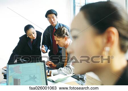 Professionals in office working together, one man looking at camera, selective focus View Large Photo Image Stock Image - Professionals in office working together, one man looking at camera, selective focus. Fotosearch