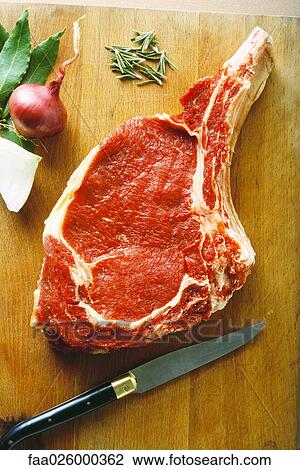 Raw steak on cutting board with herbs and knife, high angle view View Large Photo Image Stock Image - Raw steak on cutting board with herbs and knife, high angle view. Fotosearch