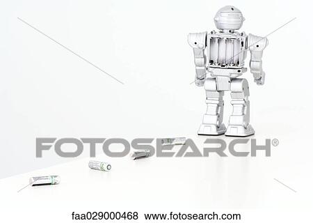 Robot leaving trail of batteries behind it View Large Photo Image Stock Photo - Robot leaving trail of batteries behind it. Fotosearch