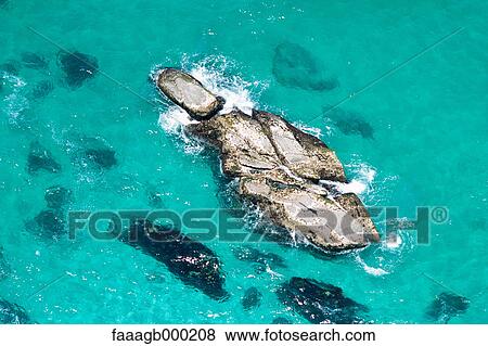 Rocks in turquoise sea View Large Photo Image Stock Photo - Rocks in turquoise sea. Fotosearch