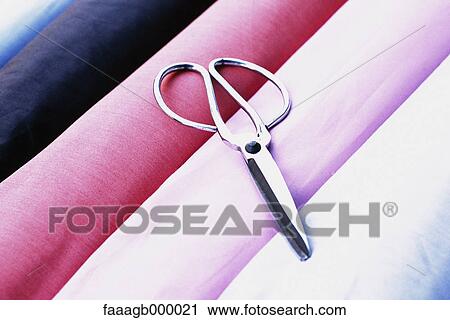 Scissors on rolls of fabric View Large Photo Image Stock Image - Scissors on rolls of fabric. Fotosearch