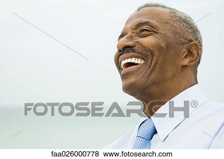 Senior businessman laughing, sea in background, head and shoulders View Large Photo Image Stock Photo - Senior businessman laughing, sea in background, head and shoulders. Fotosearch