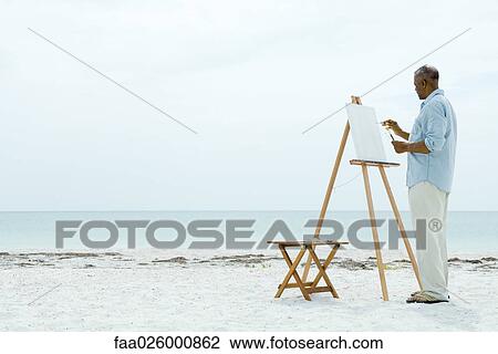 Senior man painting on canvas at the beach, side view View Large Photo Image Stock Image - Senior man painting on canvas at the beach, side view. Fotosearch